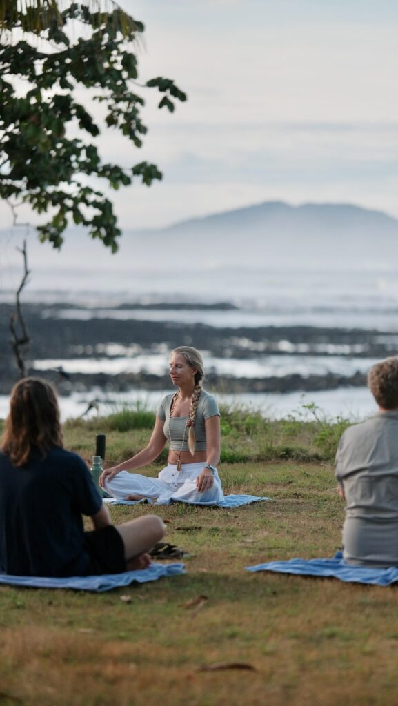 Vickie Mogensen leading a seated meditation by the sea during a Waluaa retreat